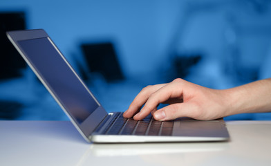 Businessman pressing modern laptop computer on colorful backgrou