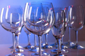 Empty wine glasses on color background