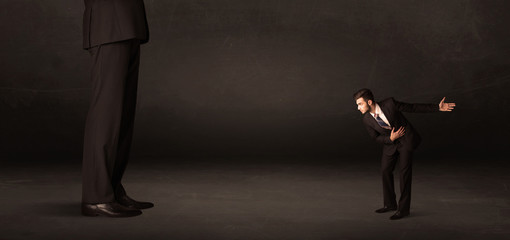 Fototapeta premium Huge man with small businessman standing at front concept