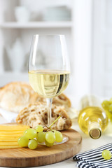Still life of wine, grape, cheese and bread on light background