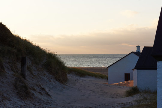small fishing houses in the dunes and view to the North sea in stenbjerg at the west coast of Denmark