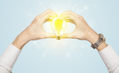 Hands creating a form with light bulb