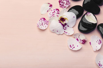 Orchid and zen stones on wooden background close-up