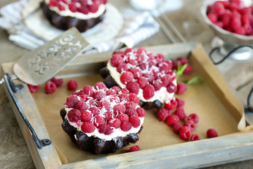 Sweet cakes with raspberries on wooden table background