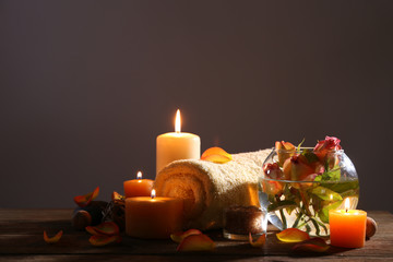 Beautiful spa composition with alight candles on wooden table