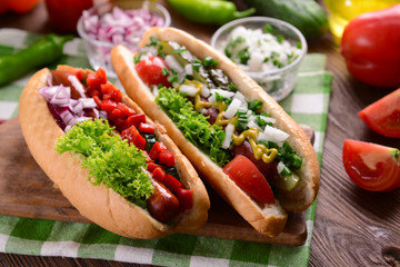 Hot dogs and vegetables on wooden cutting board