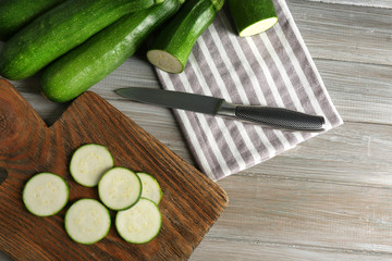 Fresh sliced zucchini on cutting board, on wooden background