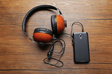 Headphones and smartphone on brown wooden background