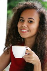 Close up portrait of young pretty woman drinking coffee