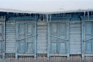 Icicles hang from a roof of the house on a chilly winter day.