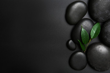 Spa stones and leaves on black background