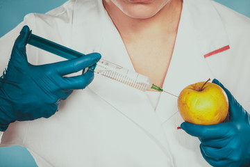 Scientist doctor injecting apple. GM Food.