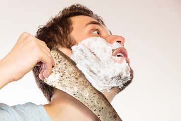 Scared man shaving having fun with machete.