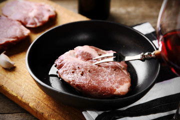 Marbled beef steak and wine bottle on wooden background