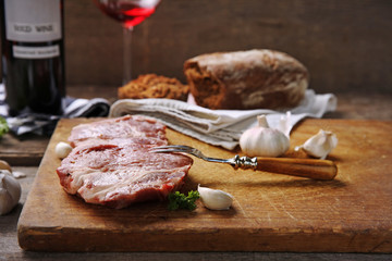 Marbled beef steak with bottle of wine and spices on wooden background