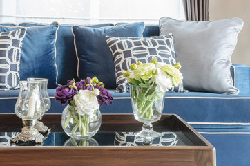 glass vase of flower on table in living room with blue classic s