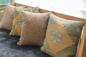 row of brown pillows on wooden sofa