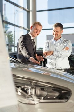 Smiling car salesman with customer