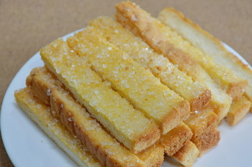 butter crispy stick bread topping sugar on dish