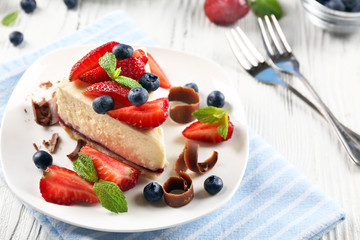Delicious cheesecake with berries on table close up