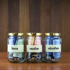 Image of money in three clear bottles with blank labels against