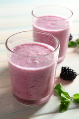 Delicious berry smoothie with blackberries on wooden table close up