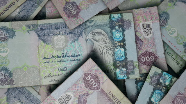 An extreme close up pan of a pile of randomly scattered dirham banknotes