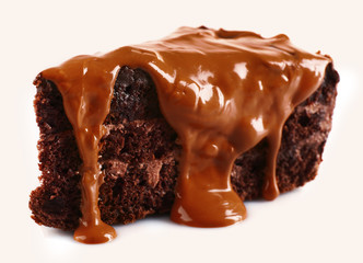 Chocolate poured on a piece of cake isolated on white