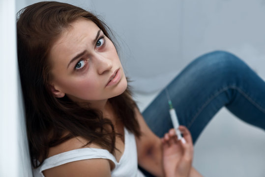 Drug addict sitting on the floor 