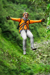 A daring man ziplining through the lush jungle of Ecuador, surrounded by vibrant nature and...