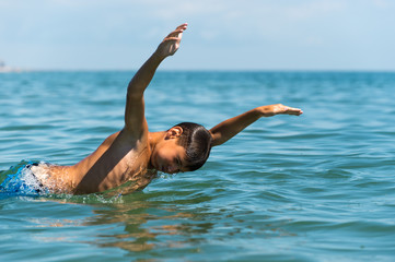 Teenager  boy enjoying a swimming in the sea.
