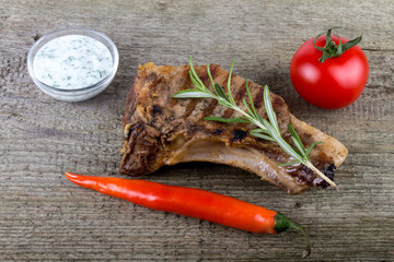 Hot grilled meat with vegetables and creamy souse on old grey wo