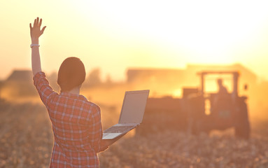 Woman with laptop and tractor