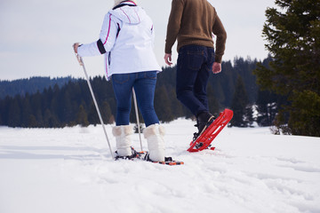 couple having fun and walking in snow shoes