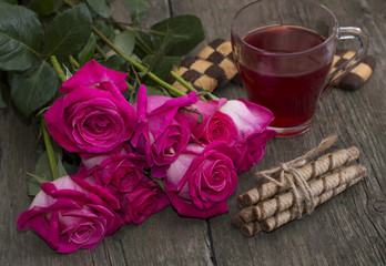 bouquet of red roses, cookies and coffee, on a wooden table, a s