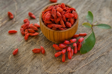 barberries and goji berries on wooden background