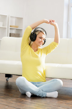 Young and beautiful teenage girl listening to the music at home