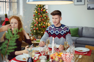 freunde sitzen zusammen beim weihnachtsessen