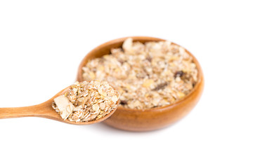 Muesli in bowl and wooden spoon on white background