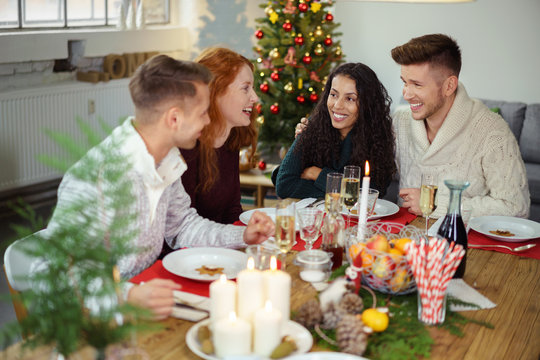 lachende freunde essen zusammen an weihnachten