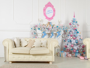 White room with a sofa, a white Christmas tree and fireplace