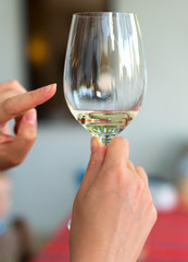 Sommelier shows on glass of white wine.
