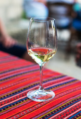 Glass with white wine on the table.