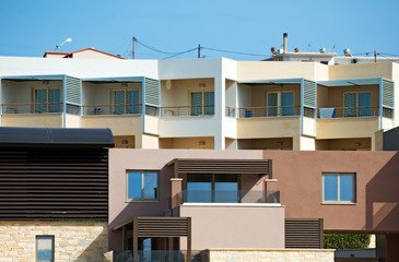 Two tropical apartment buildings with balconies.