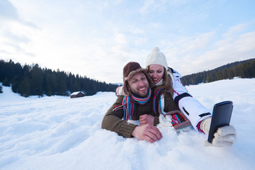 Fototapeta na wymiar romantic couple have fun in fresh snow and taking selfie