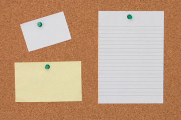 Paper note with pushpin on cork board background.
