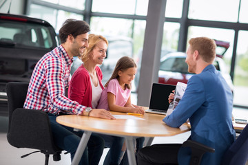 excited family in car showroom