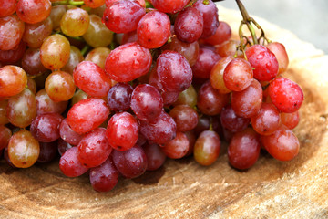 Fresh red grapes on brown wood.