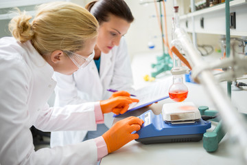 Workers in lab adjusting measuring instrument