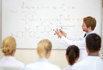 Chemical professor show molecular model in the classroom - Powered by Adobe